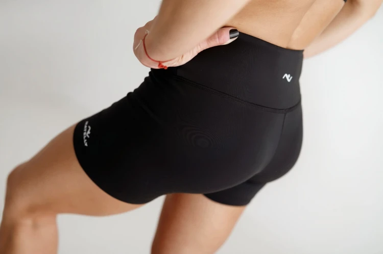 Tył czarnych krótkich getrów damskich ActiveGlow, które podkreślają kształt pośladków