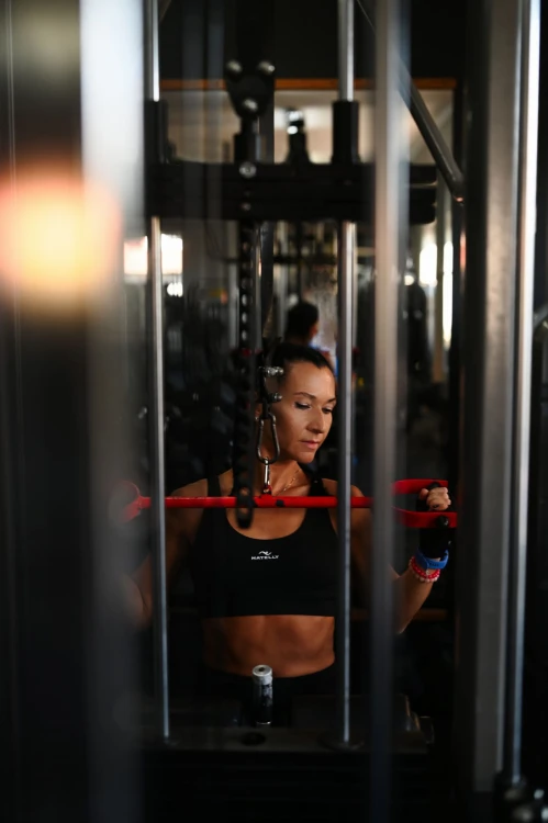 Modelka ćwiczy na siłowni w topie damskich od Natelly