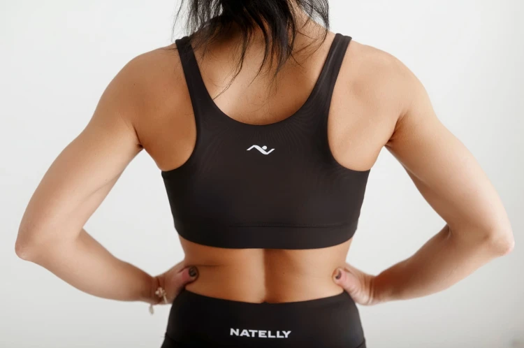 Modelka prezentuje czarny damski top ActivGlow, widok z tyłu