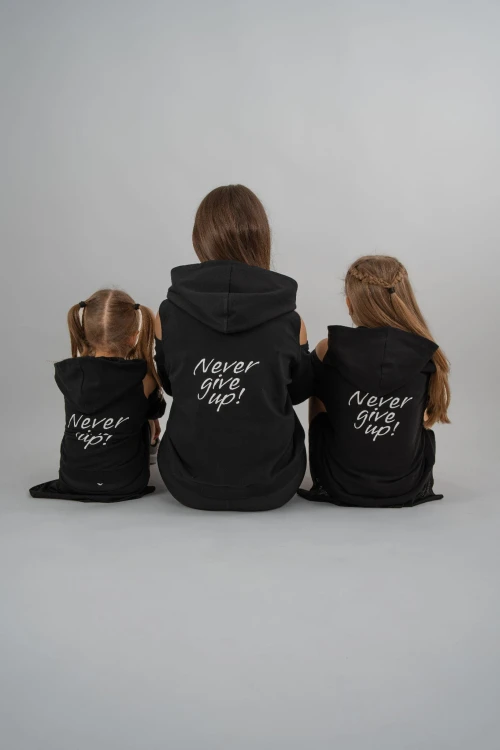 Mama i córki w bluzach z odkrytymi ramionami i napisem na plecach Never Give Up