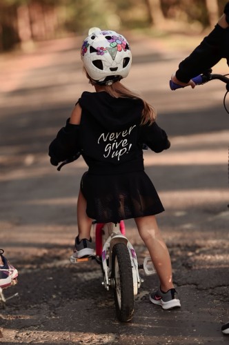 Bluza dziewczęca FLOW z odkrytymi ramionami czarna - mała modelka na rowerze