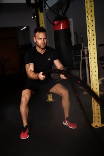 Spodenki męskie z kieszeniami Action czarne - model ćwiczy na siłowni