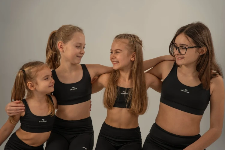 Cztery modelki patrzą na siebie uśmiechając się - czarny top dziewczęcy