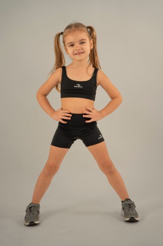 Mała modelka prezentuje czarne szorty dziewczęce ActiveGlow z przodu