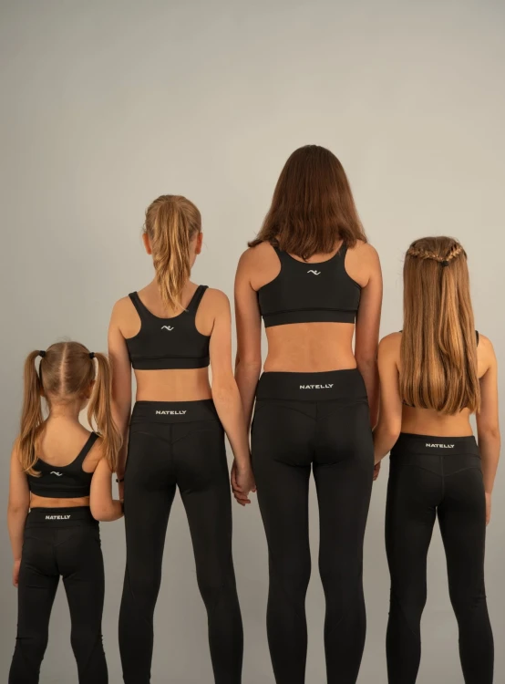 Cztery modelki tyłem w legginsach dziewczęcych ActiveGlow, widoczne przeszycia i pas z logo