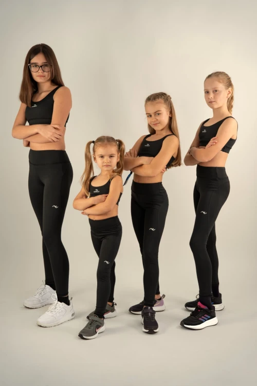 Cztery modelki bokiem w legginsach dla dziewczynki, podkreślone przeszycia i dopasowanie kroju