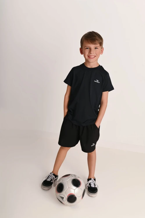 Spodenki chłopięce z kieszeniami Action czarne - model pozuje z piłką