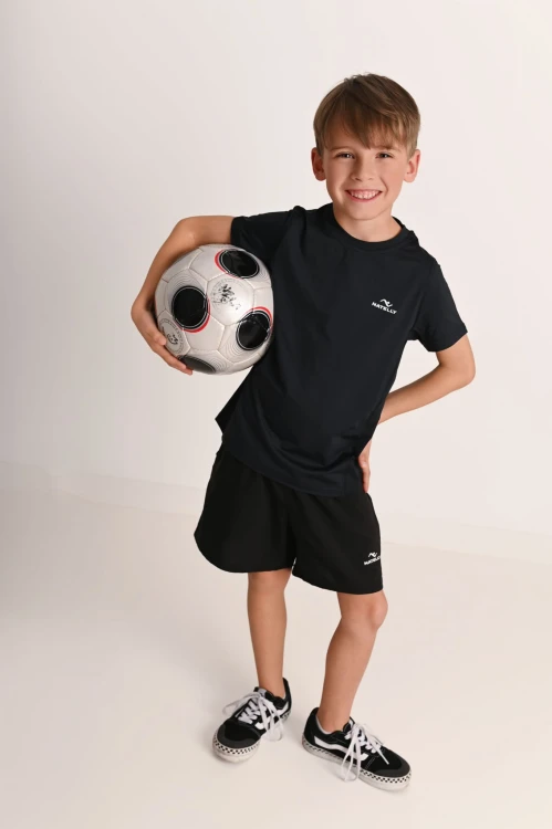 Koszulka chłopięca z przeszyciami i odblaskiem Action czarna - model z piłką pod pachą