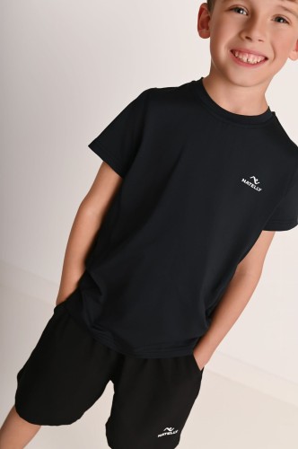 Koszulka chłopięca z przeszyciami i odblaskiem Action czarna - model w luźnej pozie