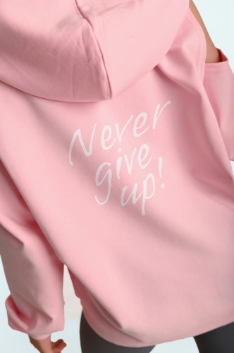 Tył bluzy w kolorze pudrowy róż z odkrytymi ramionami i napisem Never Give Up