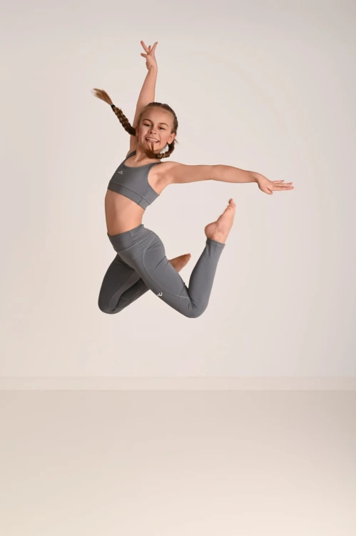 Legginsy dla dziewczynki z przeszyciami ActiveGlow szare - modelka w skoku