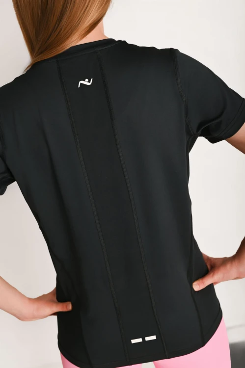 Koszulka damska z przeszyciami i odblaskiem Action czarna - modelka stoi tyłem